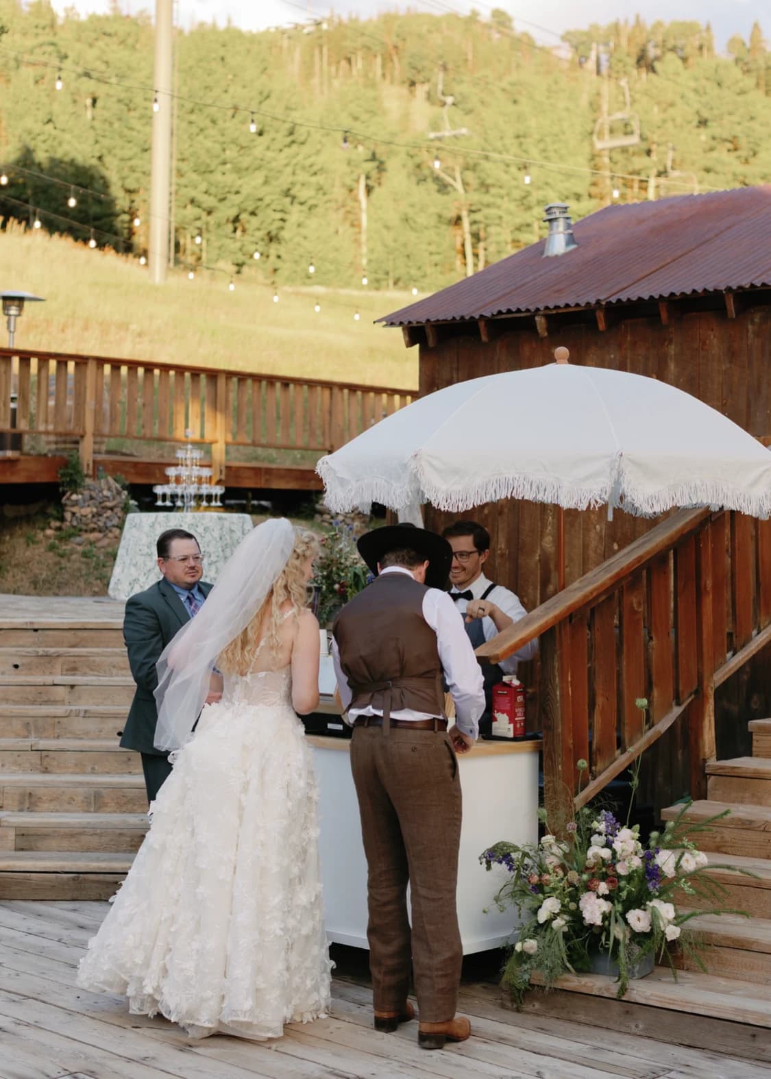Bride and groom ordering at a Flipside coffee cart on a mountain deck with a ski lift behind