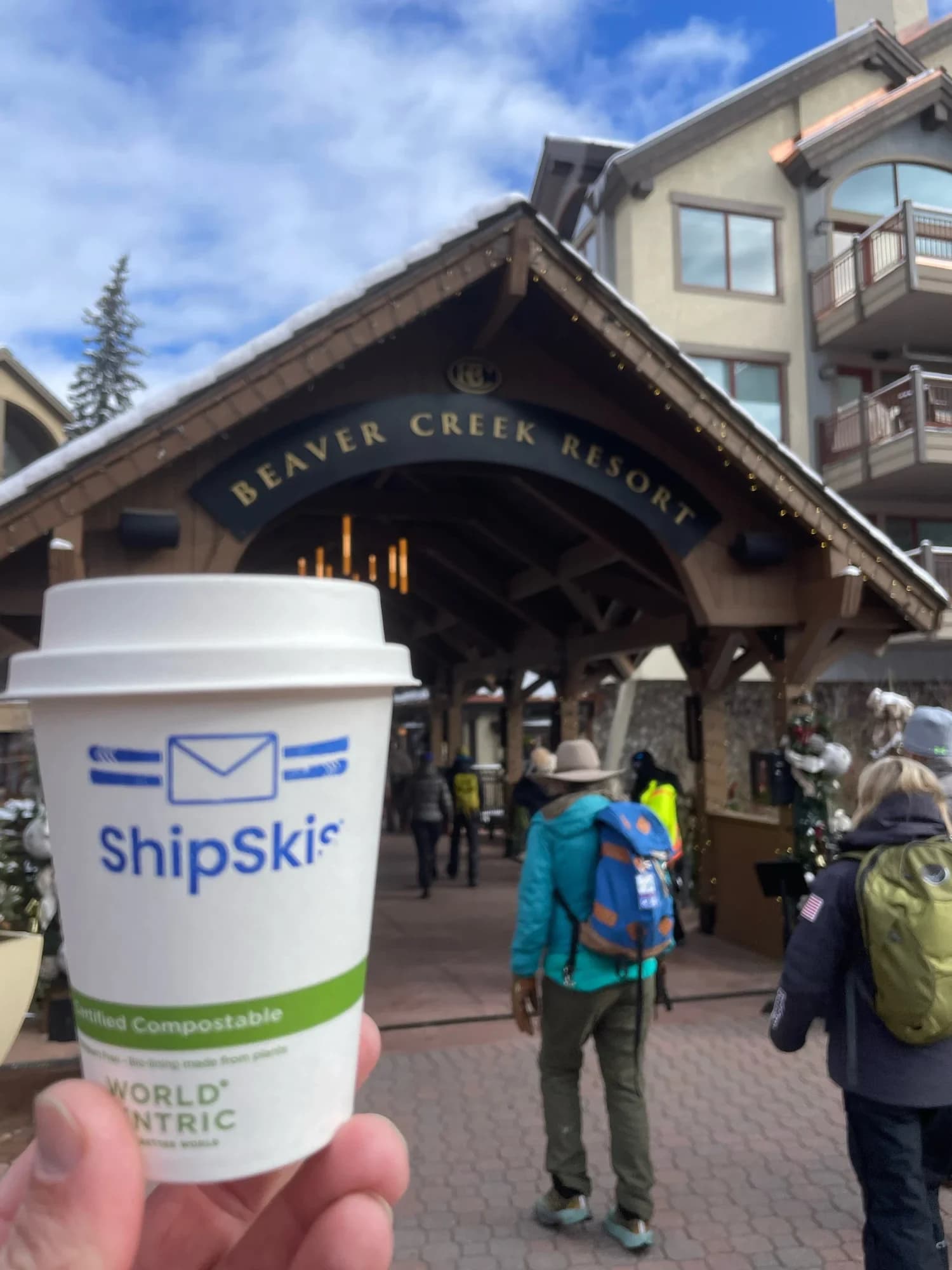 Branded Flipside coffee cup in front of the Beaver Creek Resort arch