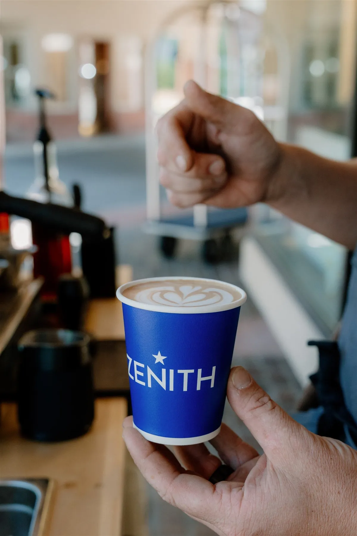 Barista steaming milk behind a Flipside coffee cart
